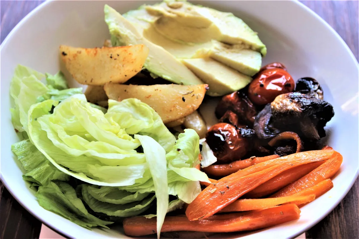 Assiette composée de légumes croquants en salade, légumes rôtis et féculents complets variés