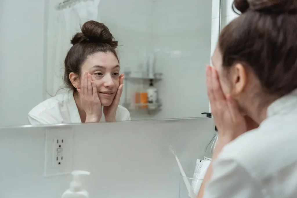Produits de soin et crème solaire sur une vanité de salle de bain baignée de lumière naturelle estivale