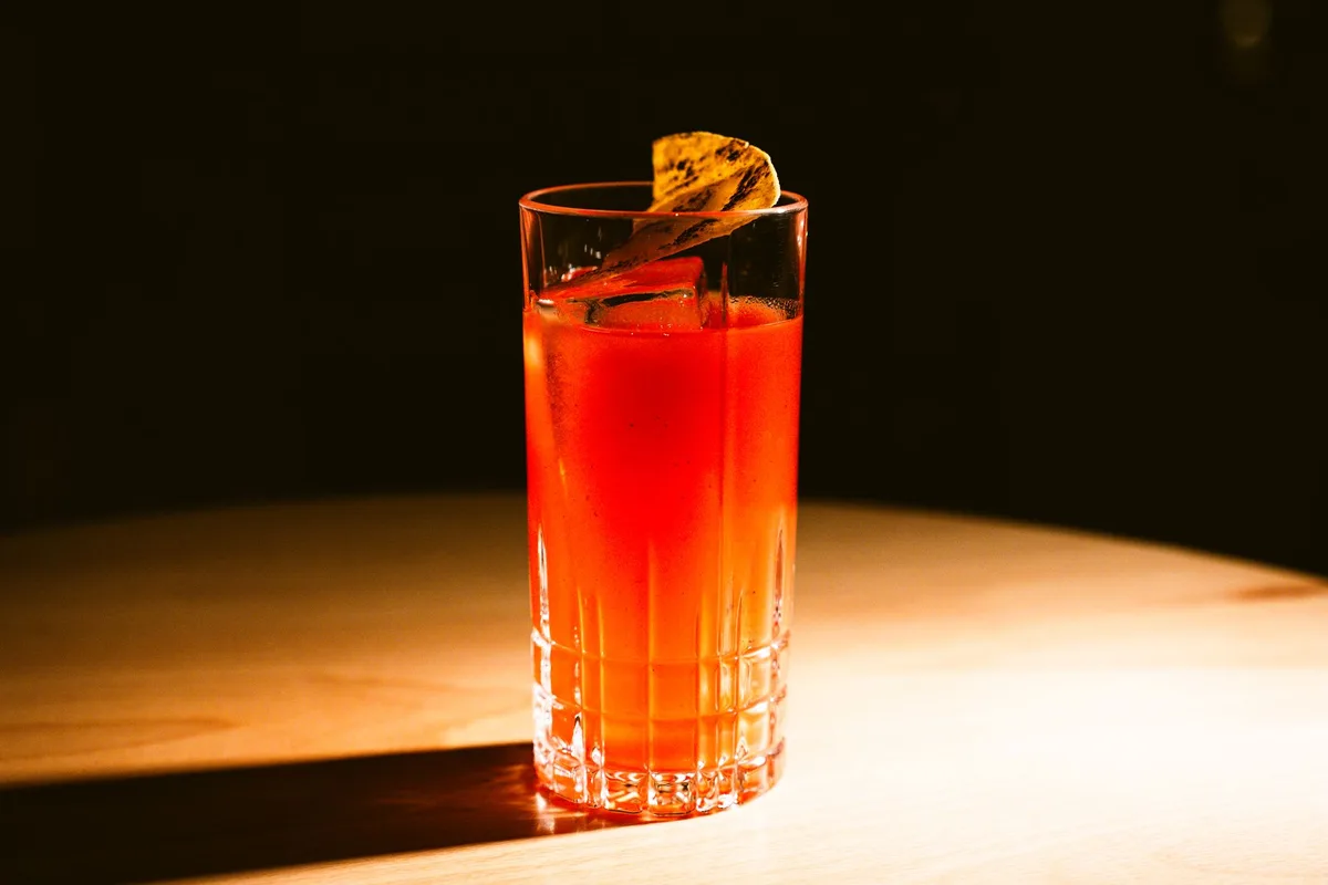 Comptoir d'un bar intime avec verres artisanaux et ambiance tamisée