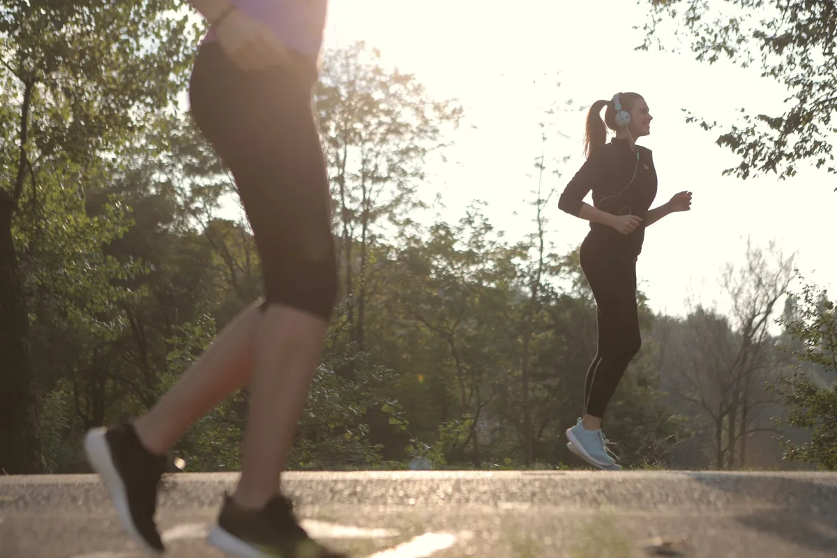 Personne en train de faire de l'exercice tôt le matin dans un parc frais.