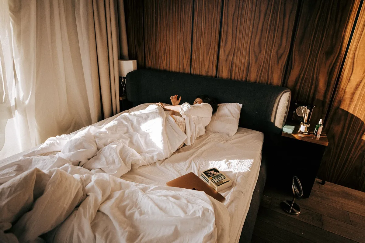 Personne endormie paisiblement dans un lit baigné de lumière naturelle du matin