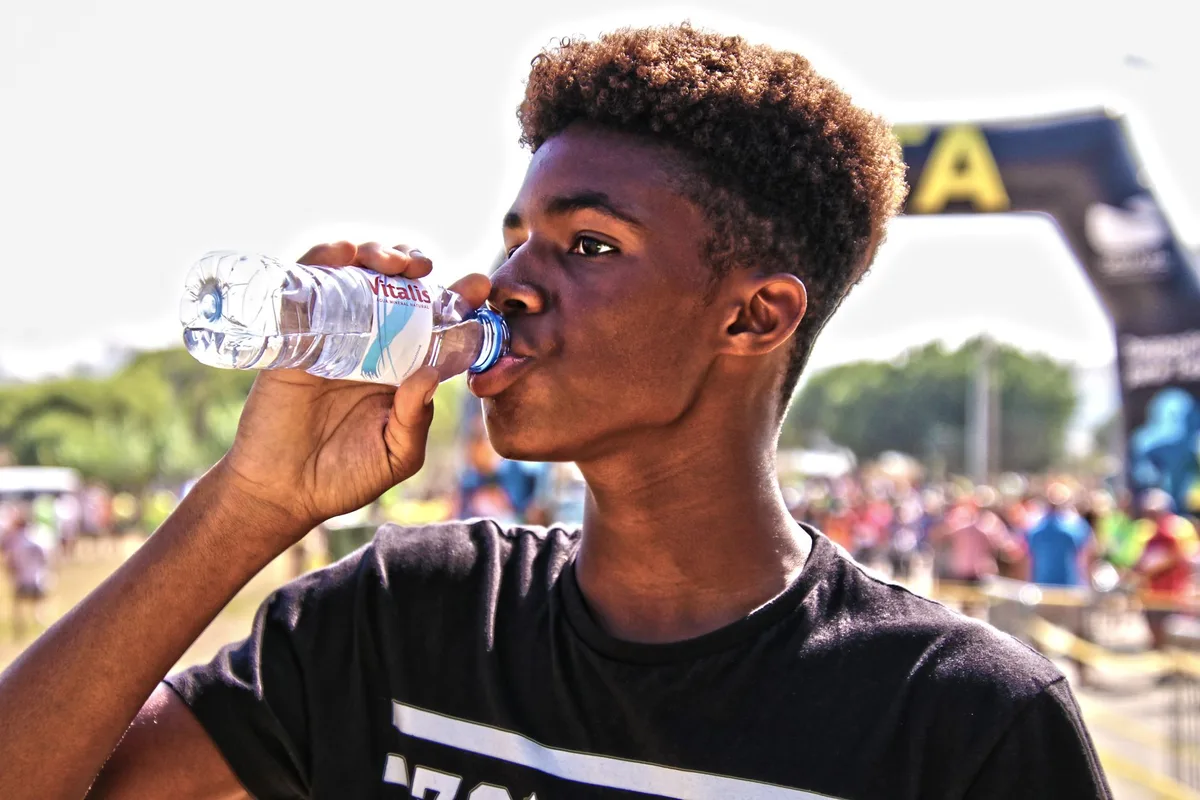 Personne buvant de l'eau fraîche et se rafraîchissant le visage pour combattre la chaleur