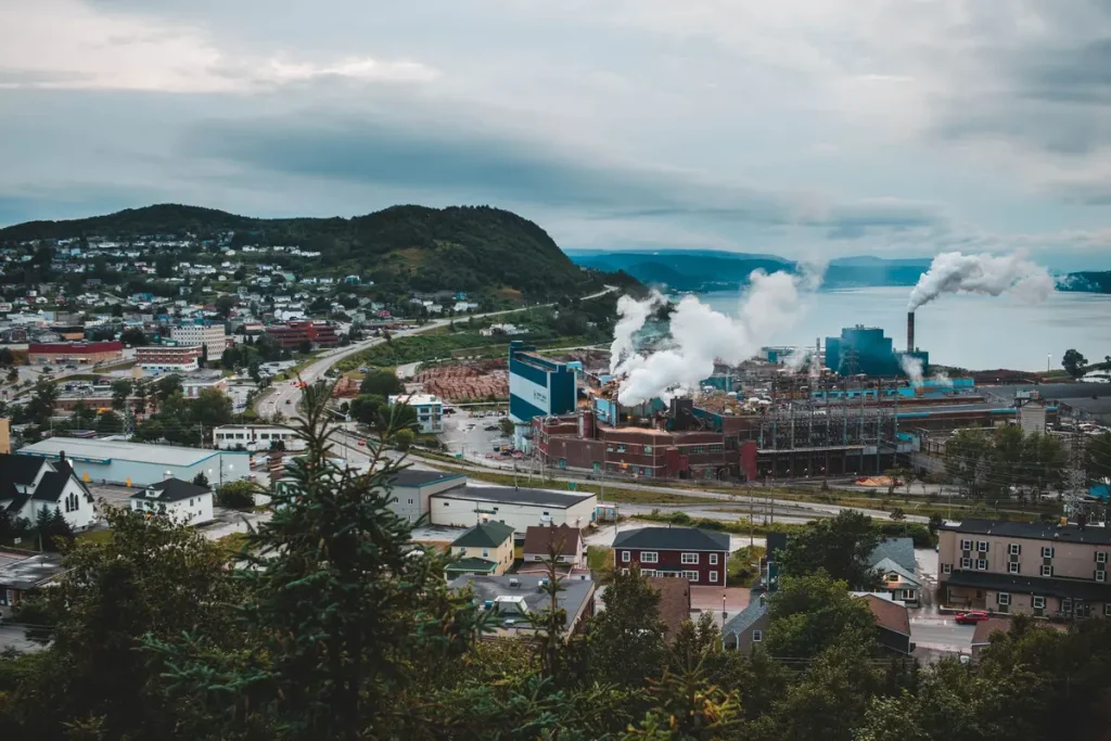 Vue d'une fenêtre sur un quartier urbain défavorisé avec pollution atmosphérique visible