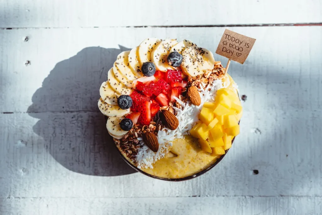 Smoothie aux fruits rouges et banane dans un verre avec des ingrédients frais à côté