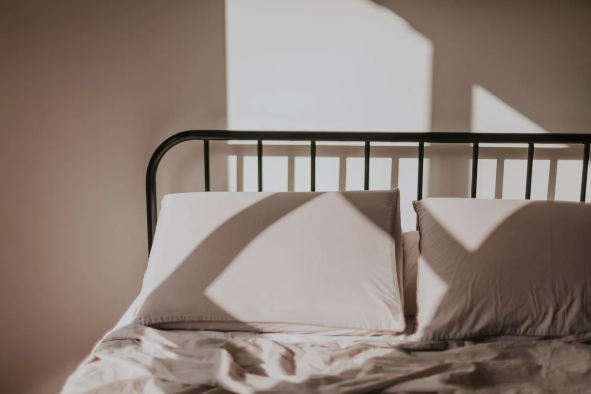 Personne dormant paisiblement dans un lit bien éclairé par la lumière du jour