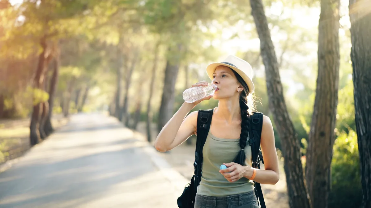 Kit d'équipement estival : bouteille d'eau, crème solaire, chapeau et vêtements légers