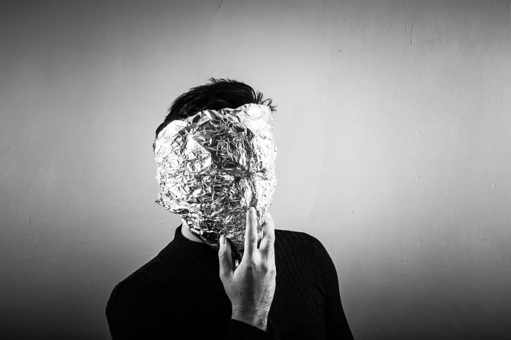 Mains emballant des aliments dans du papier aluminium sur un plan de travail de cuisine