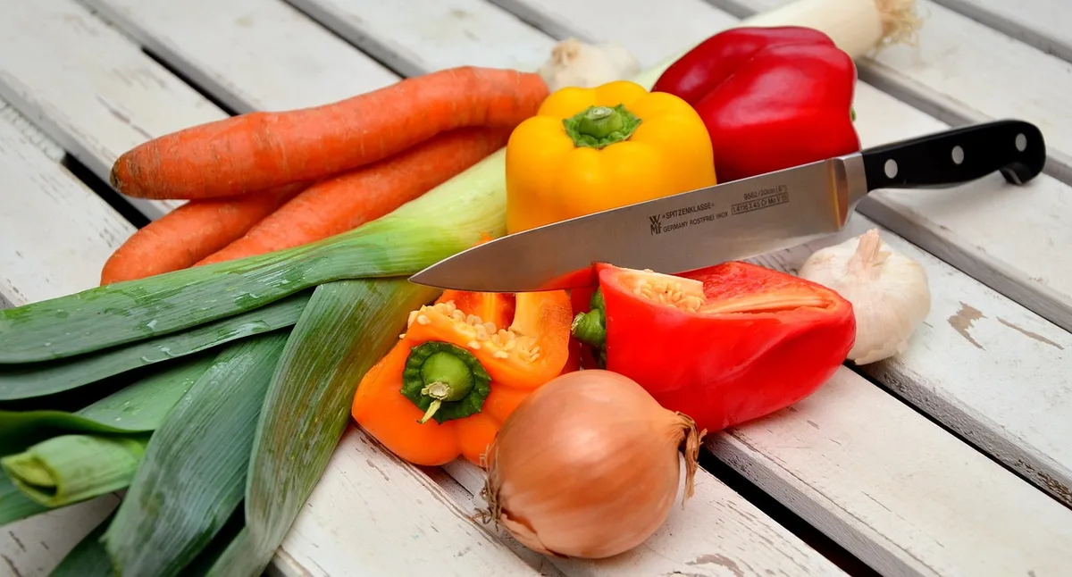Assiette équilibrée avec légumes colorés, céréales complètes et protéines maigres sur une table en bois