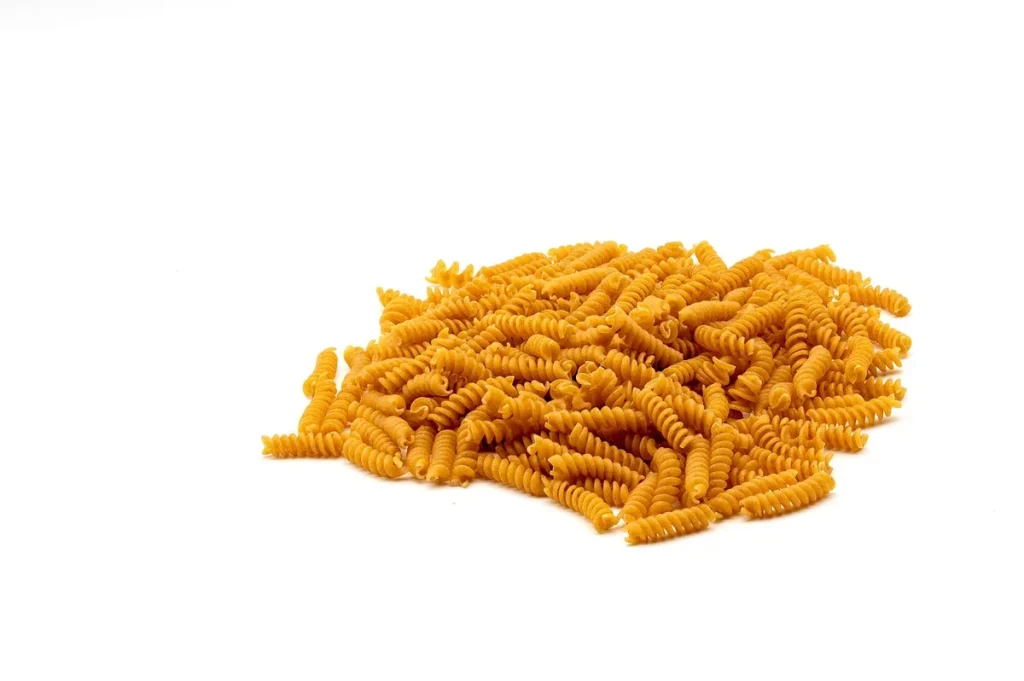 Assortiment d'aliments sains : légumes frais, céréales complètes, légumineuses et huile d'olive sur une table en bois