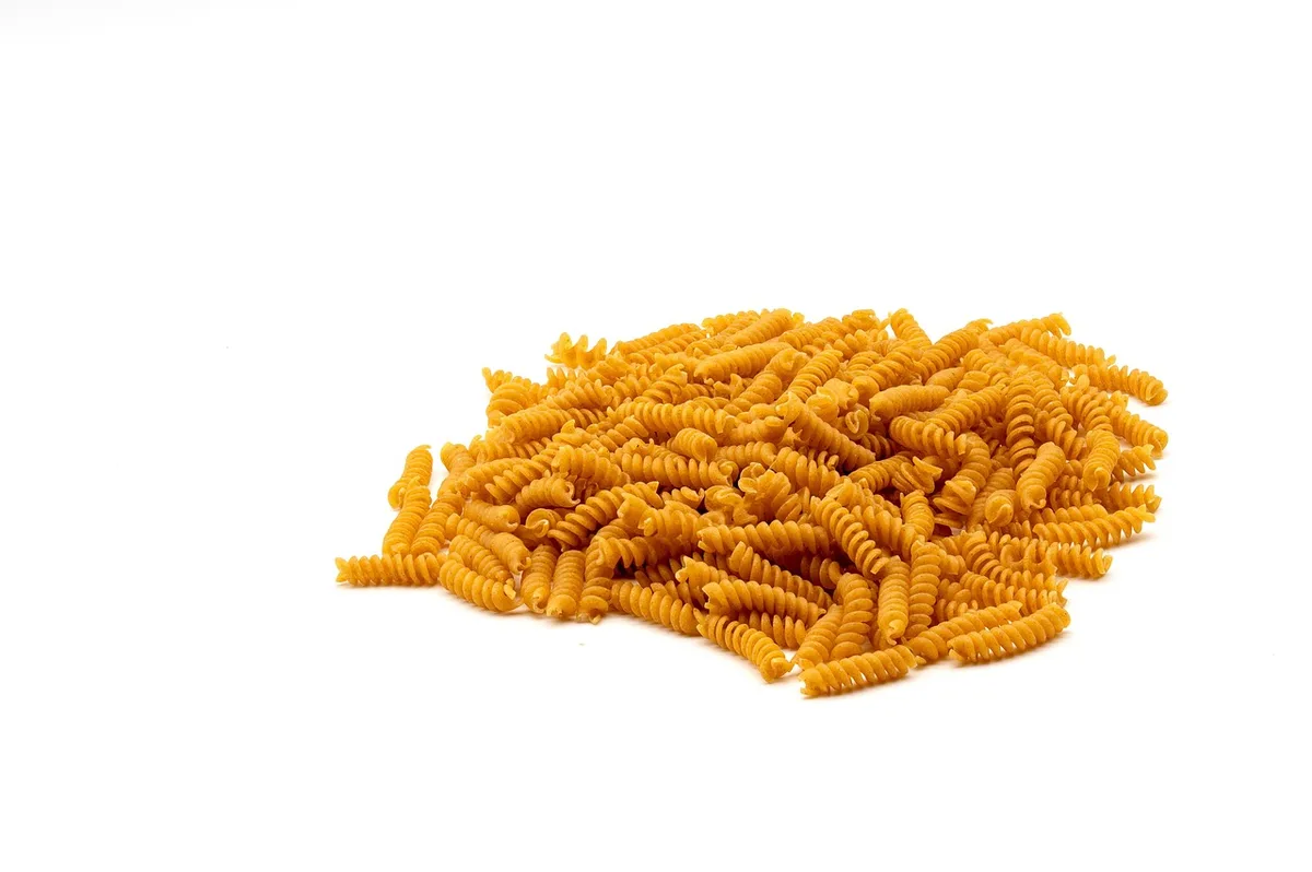 Assortiment d'aliments sains : légumes frais, céréales complètes, légumineuses et huile d'olive sur une table en bois