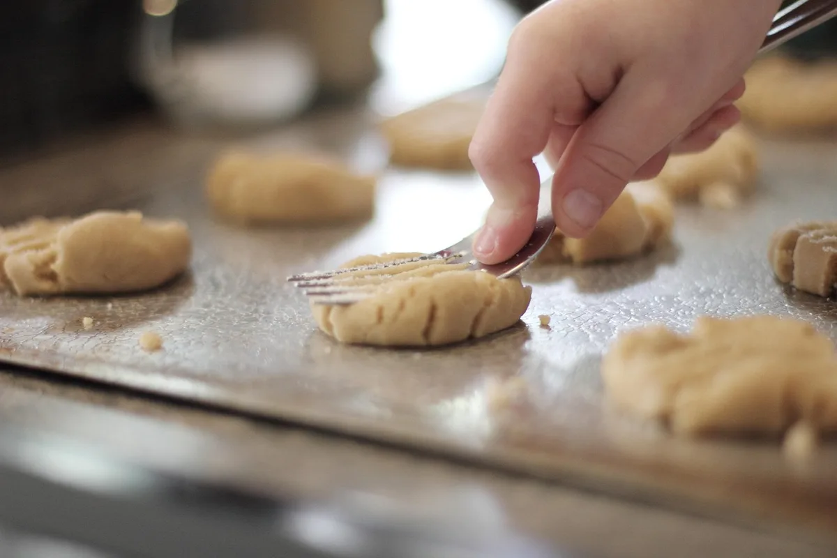 Enfant préparant un goûter maison à la cuisine avec un adulte