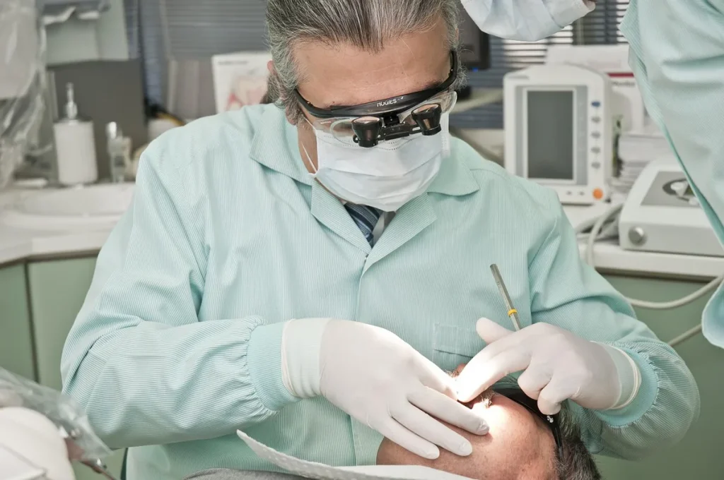 Mains gantées de chirurgien effectuant une extraction et implantation de greffons capillaires en clinique.