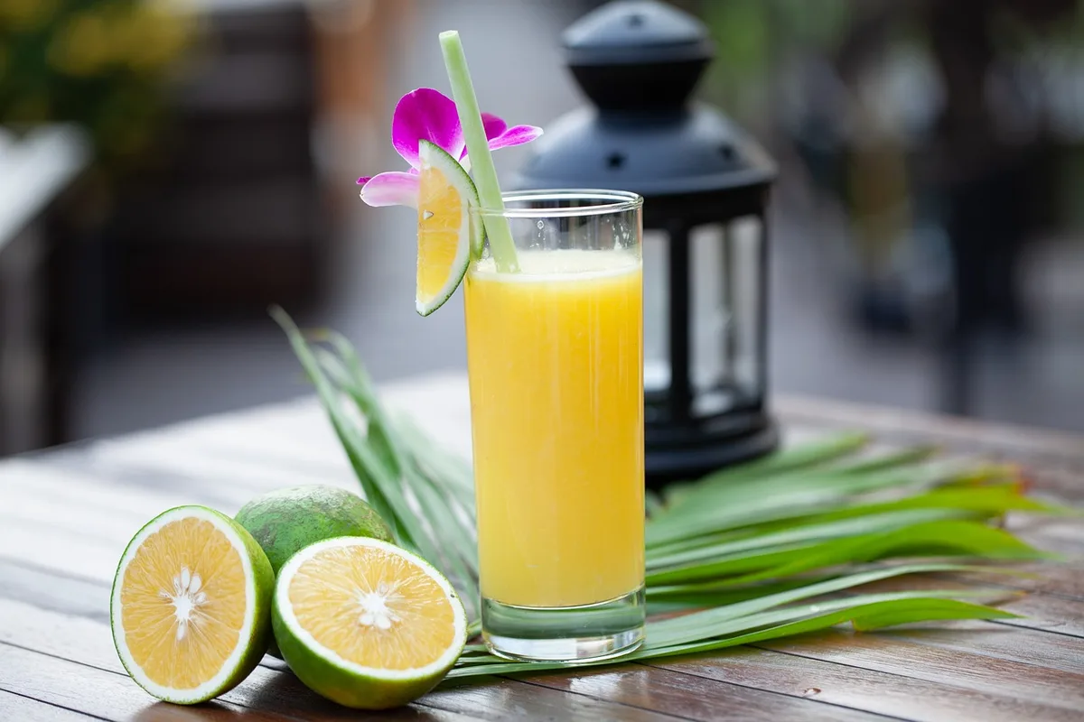 Pichet et verre de limonade maison avec citrons coupés à côté
