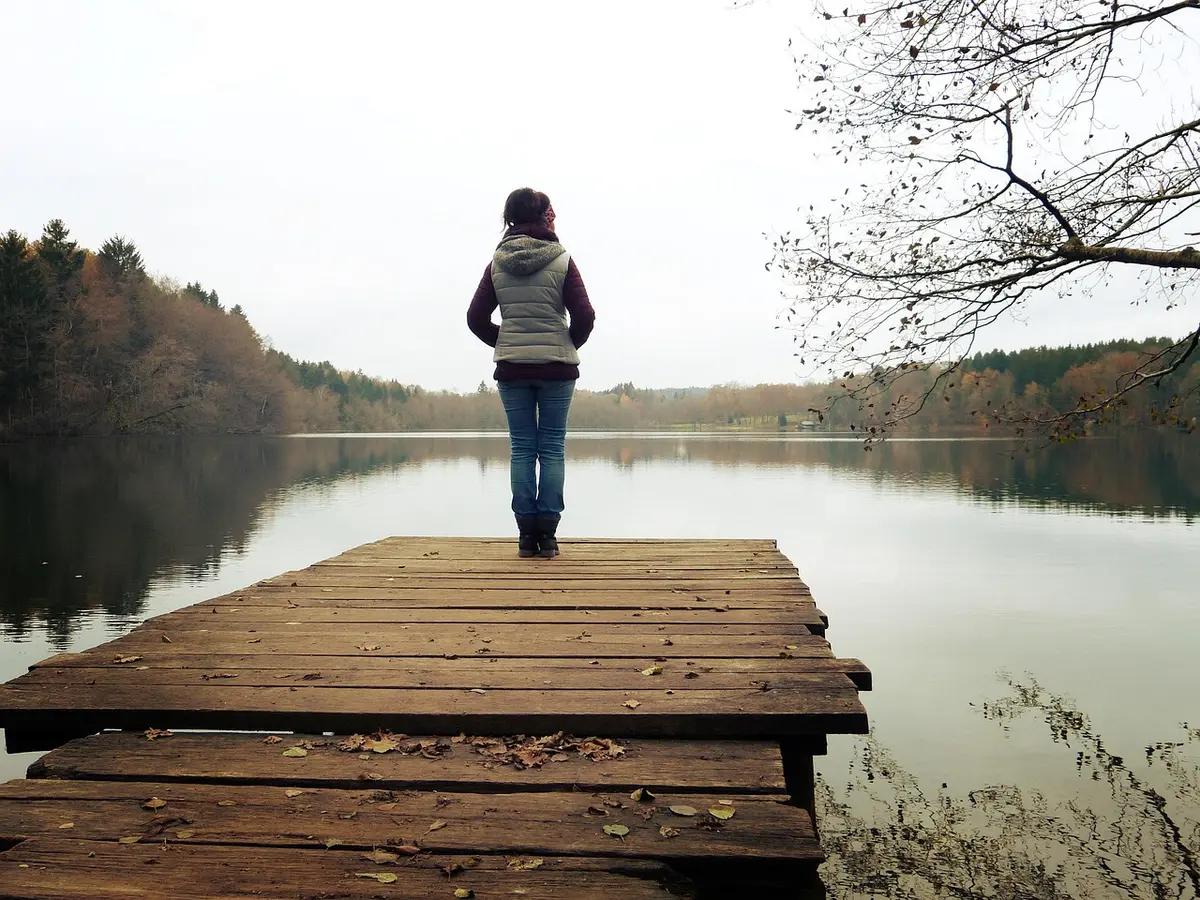 Femme pensive à une table, évoquant changements hormonaux et humeur