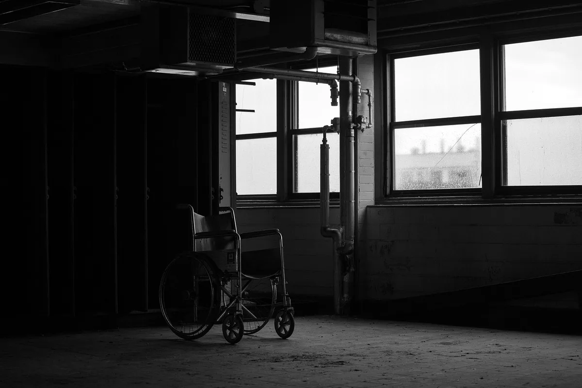 Couloir d'hôpital désert avec un fauteuil roulant et une blouse accrochée, ambiance urgente