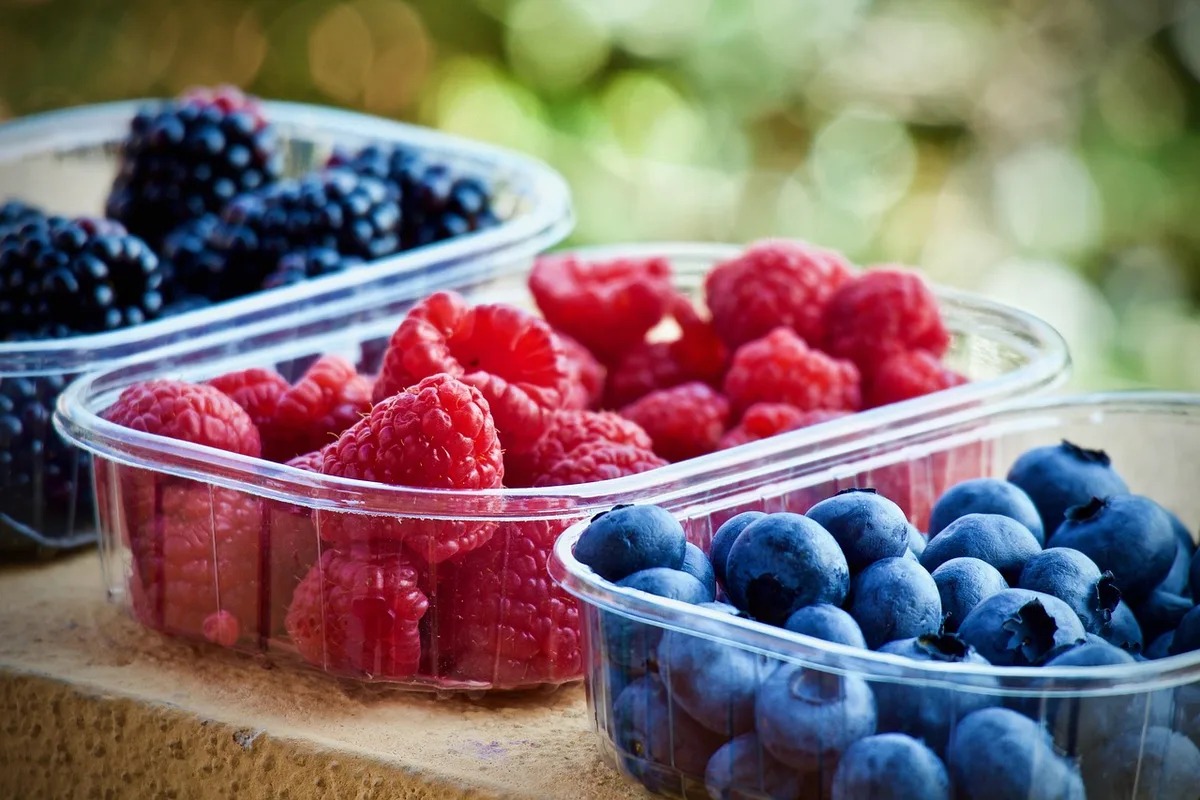 Sélection de collations pratiques dans un sac et sur un bureau : fruits secs, barres et yaourt