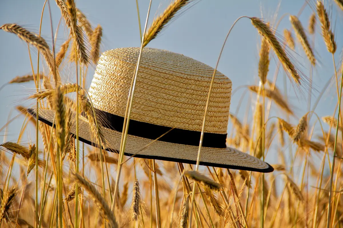 Colliers, chapeau et foulard posés sur une table claire
