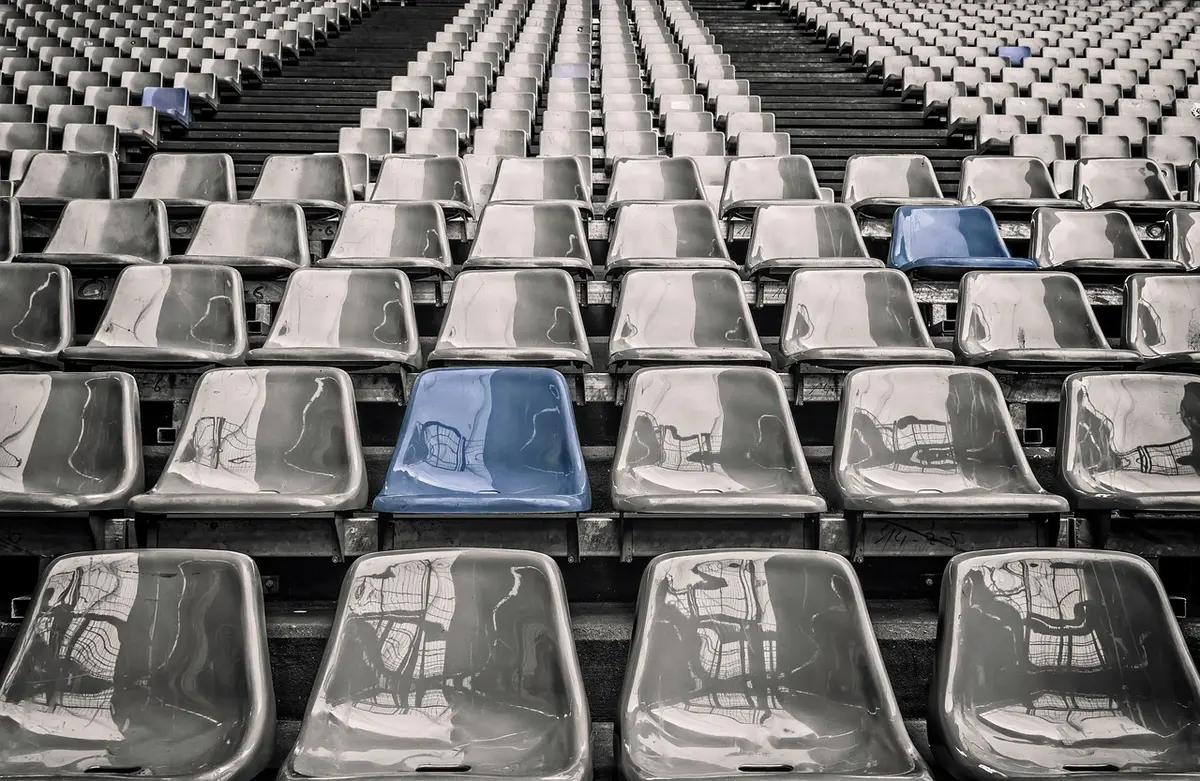Foule de spectateurs dans les gradins d'un stade illuminé en soirée