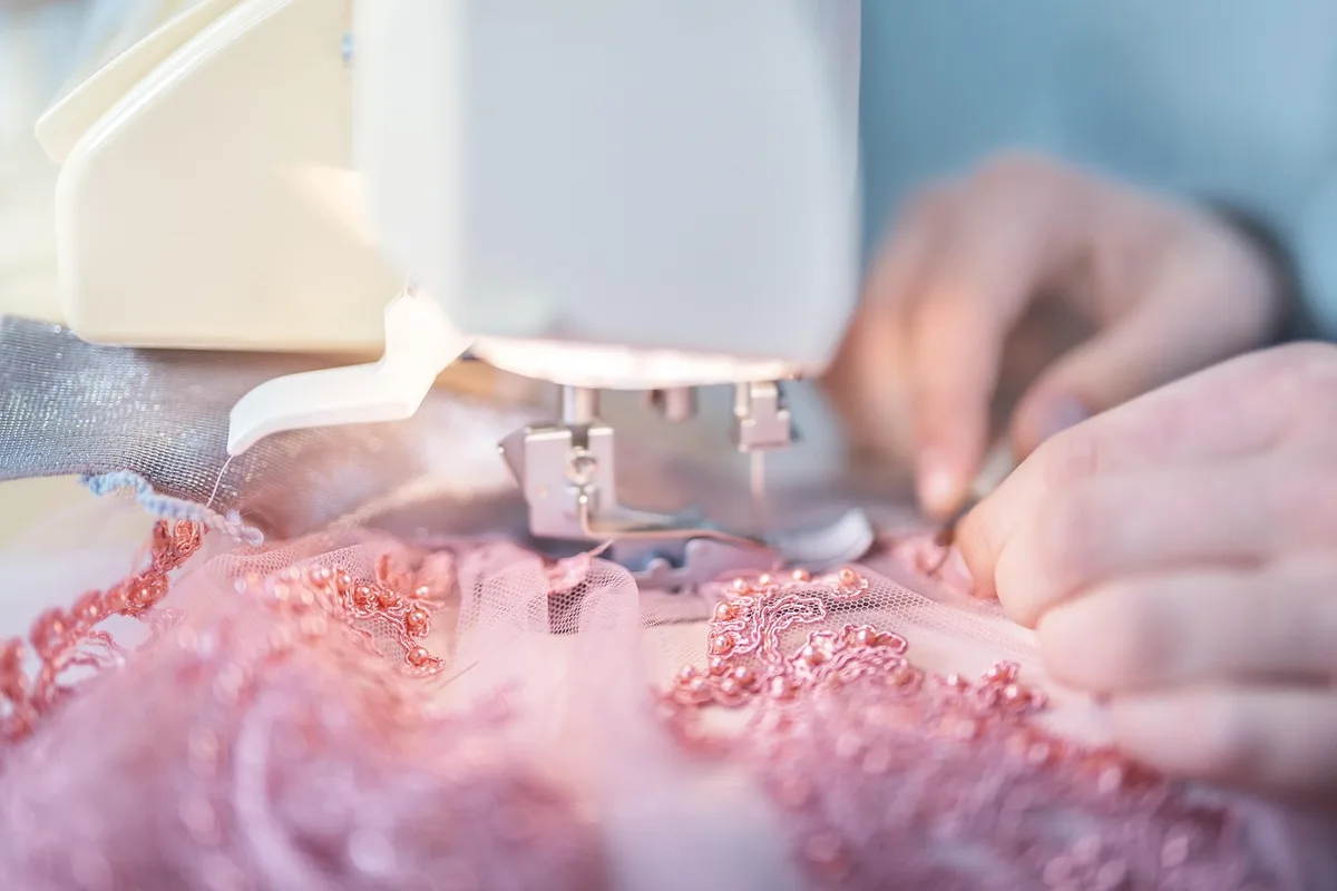 Kit de couture et personne ajustant un ourlet à la lumière du jour