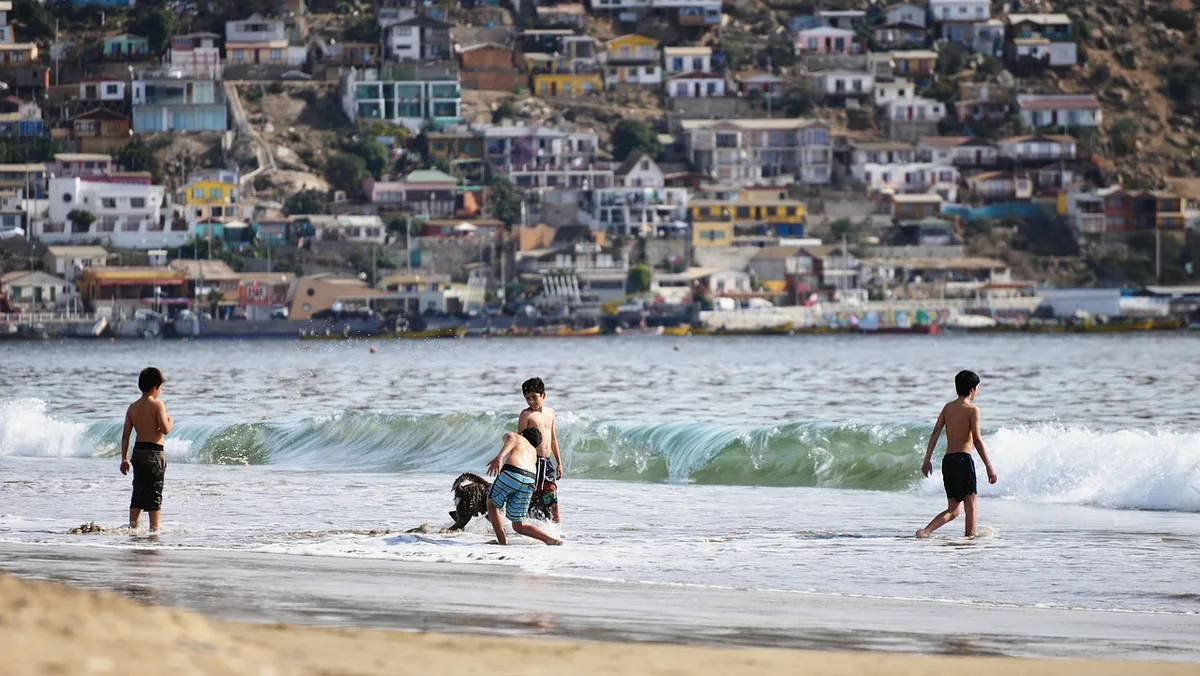 Enfants jouant librement sur la plage, construisant avec le sable