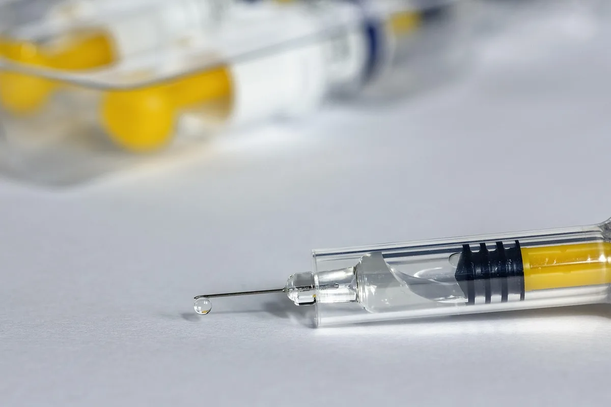 Professionnel de santé préparant une injection intramusculaire dans le deltoïde