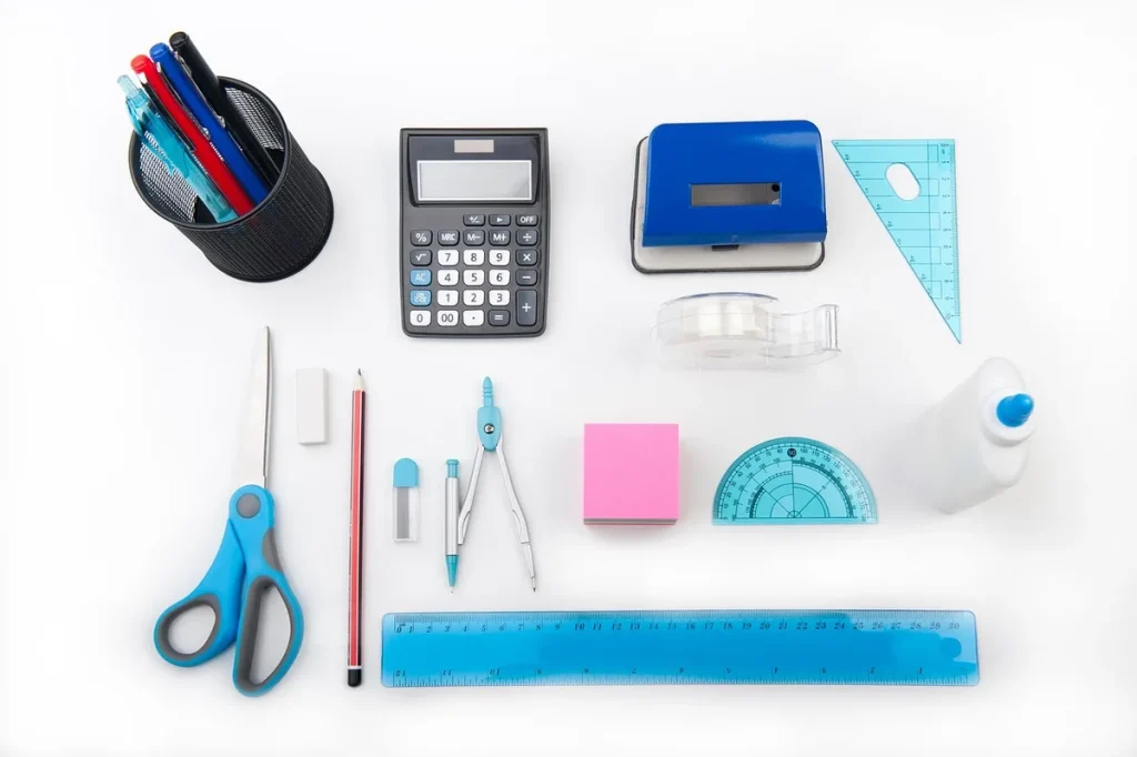 Table de cuisine en plein jour avec calculatrice, carnet et mètre ruban, mains anonymes saisissant des chiffres