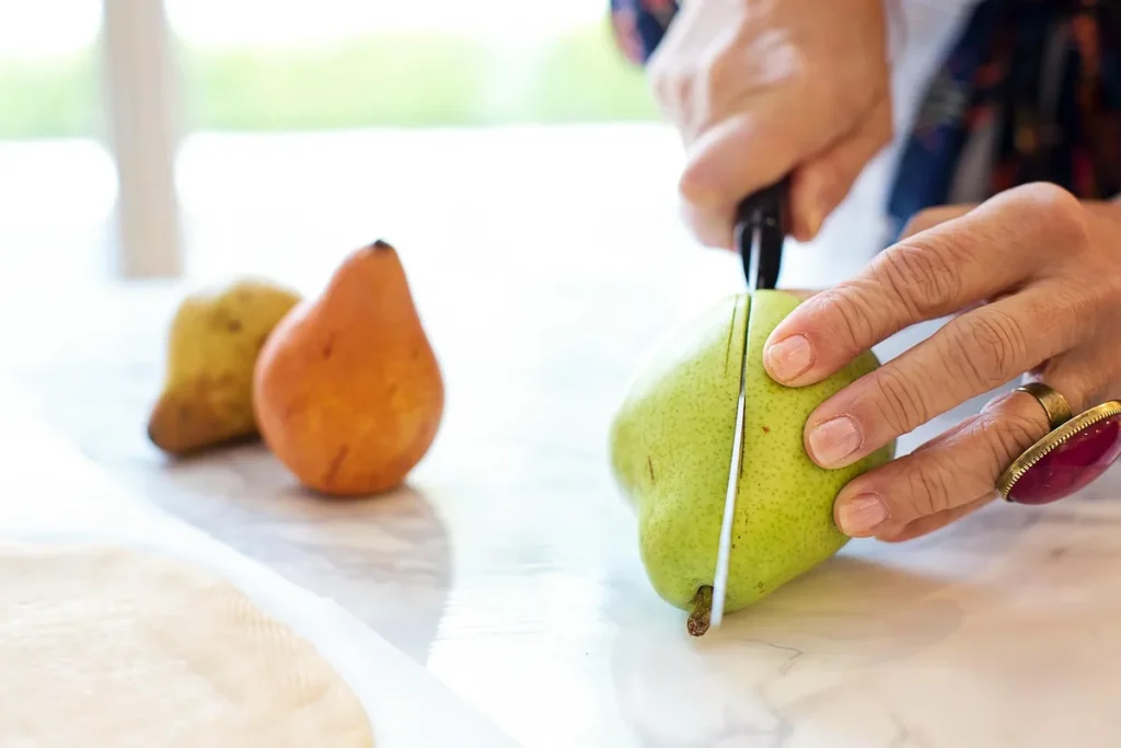 Bol de compote et poires rôties sur une table de cuisine en lumière du jour