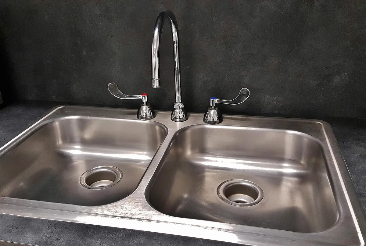 Système d'osmose inverse installé sous un évier domestique avec réservoir visible