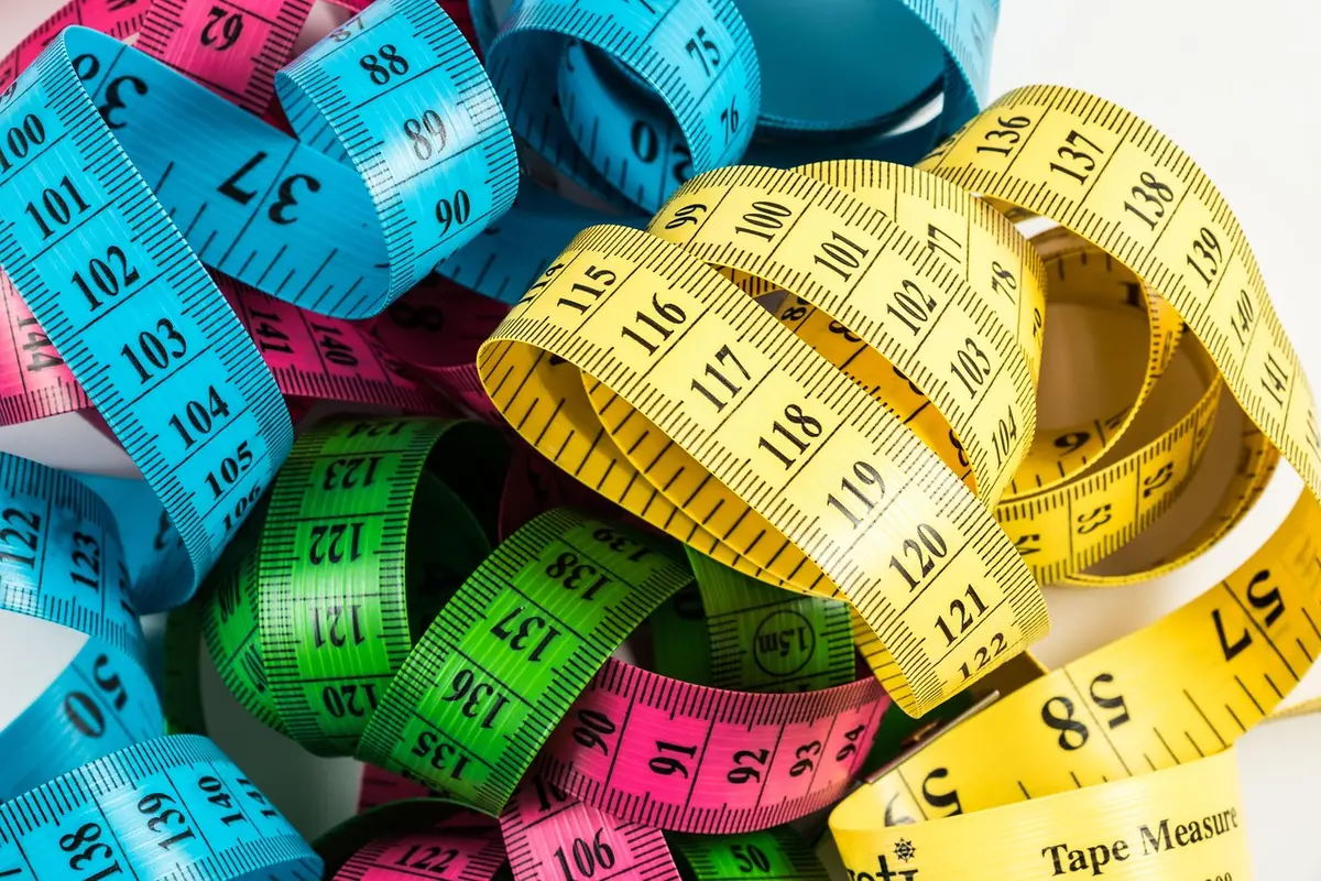 Tour de taille et mètre ruban posés sur une table pour illustrer la composition corporelle