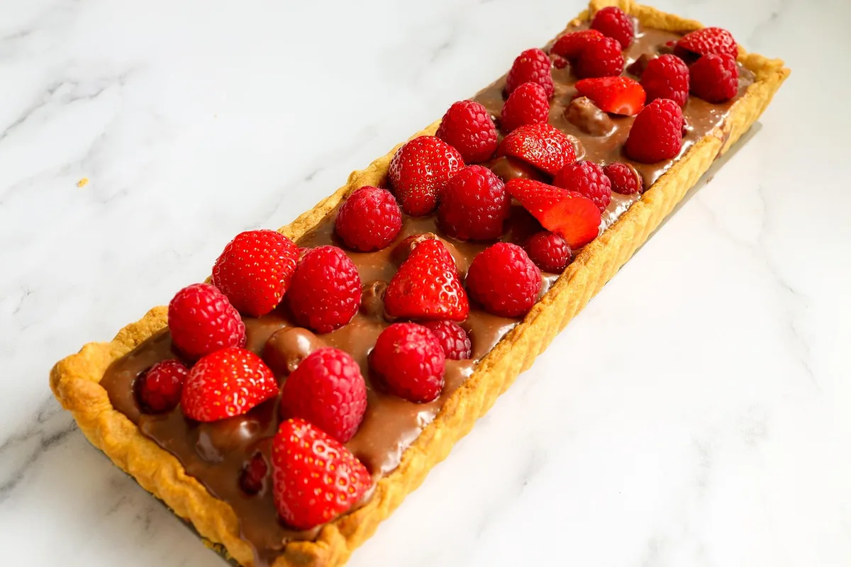 Verrines de mousse au chocolat garnies de fruits rouges sur une table