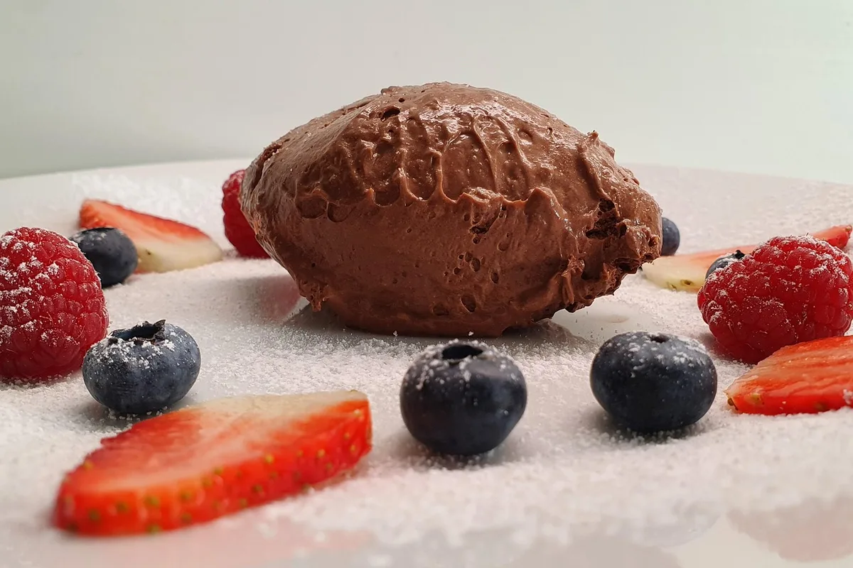 Verrines de mousse au chocolat sans sucre posées sur un plan de travail en cuisine, lumière du jour
