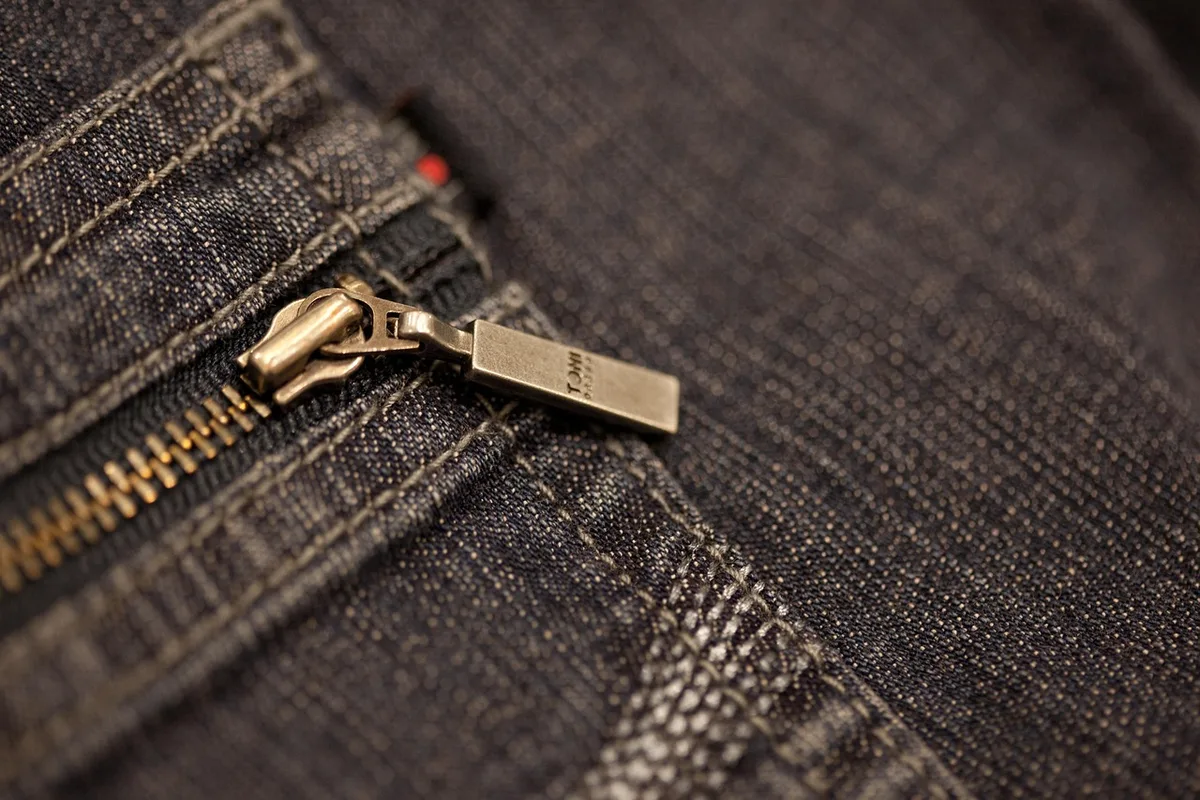 Différentes coupes de pantalons posées sur un portant, droites et larges