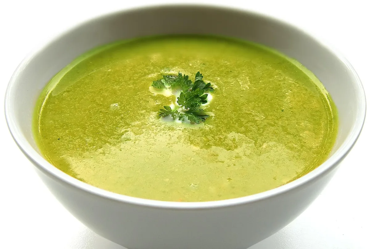 Bowl de légumes, verre d'eau et un carnet de repas sur une table de cuisine en journée