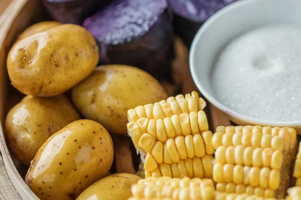 Table de cuisine en plein jour avec bol de féculents complets et légumes, main prenant une fourchette