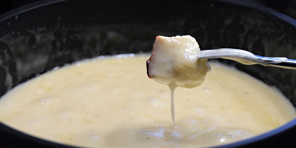Main posant une fourchette entre les bouchées près d'une assiette