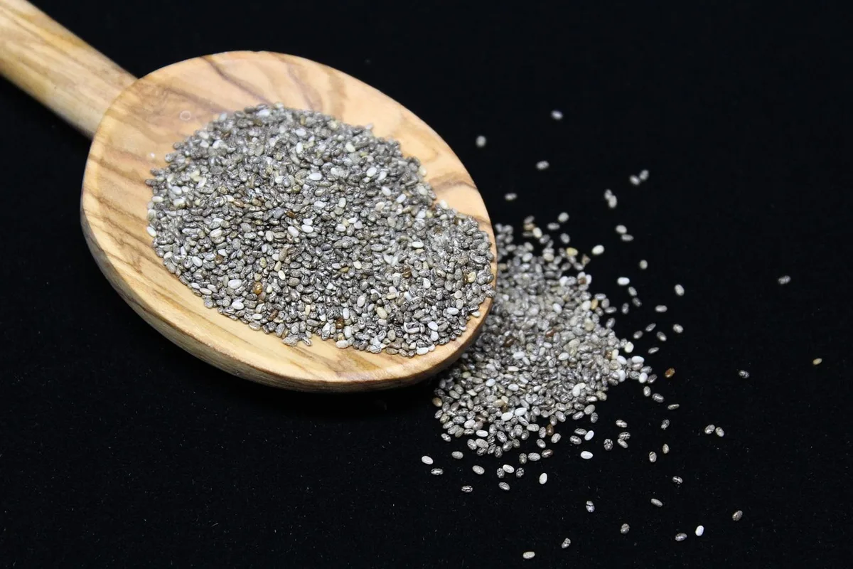 Mains mélangeant des graines de chia et du lait dans un bol