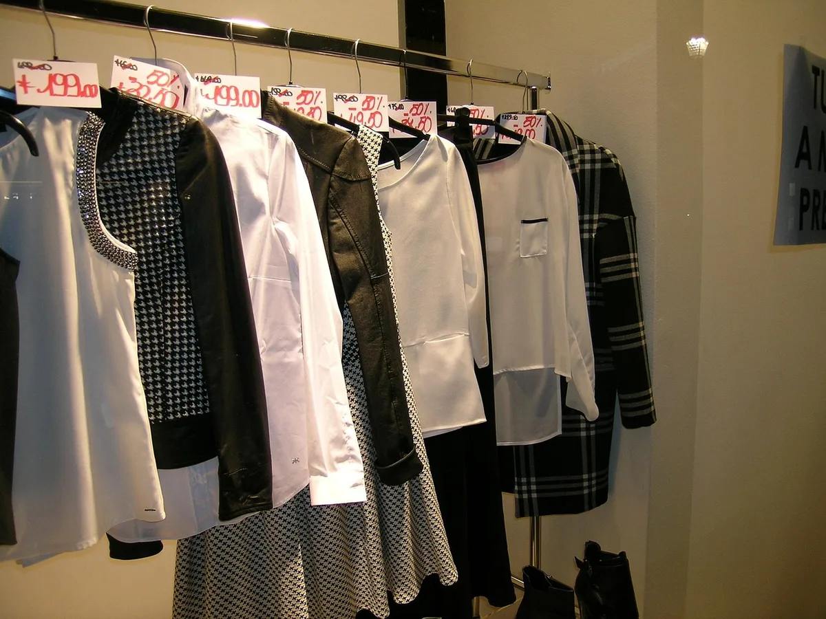 Client essayant une veste dans une cabine claire