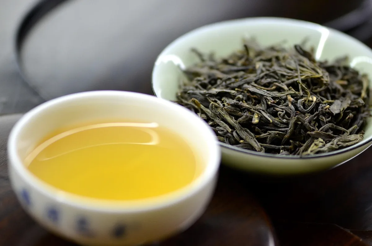 Infusion de thé en cours avec feuilles en vrac et théière